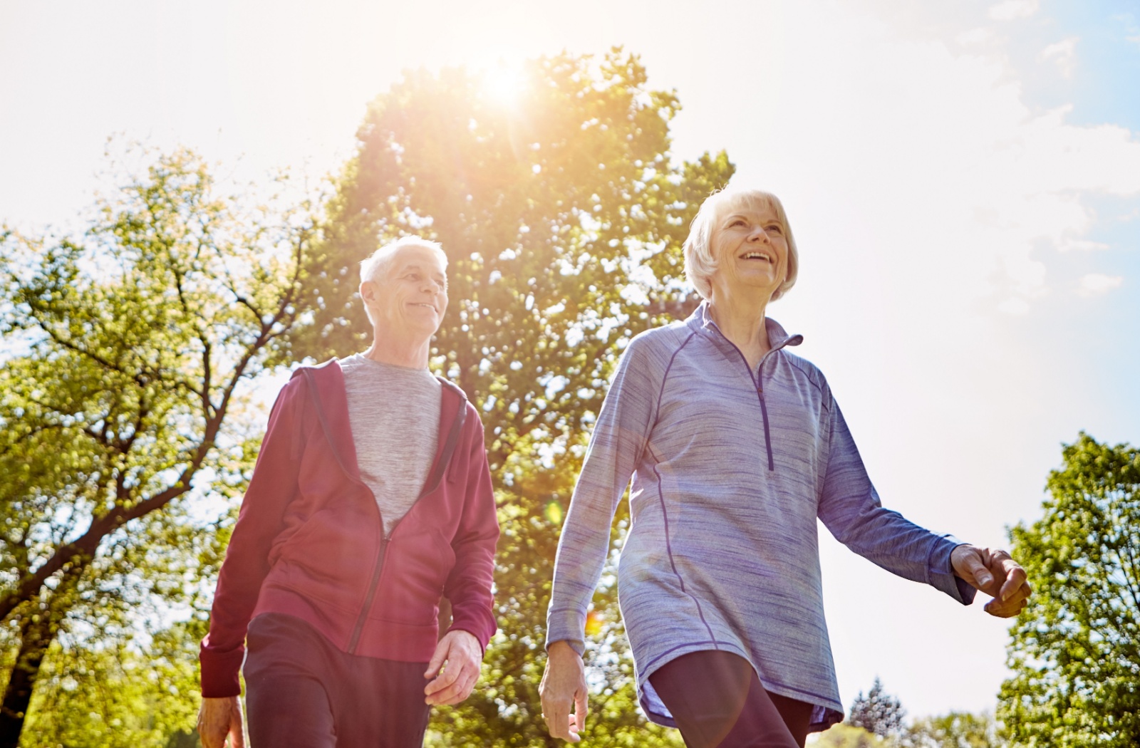 A senior couple enjoys a low-impact stroll on a crisp spring day.